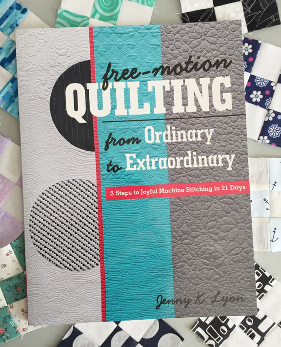 Image of the cover of Jenny K. Lyon's book, titled Free-Motion Quilting from Ordinary to Extraordinary. The book rests on a background of small nine-patch quilt blocks.