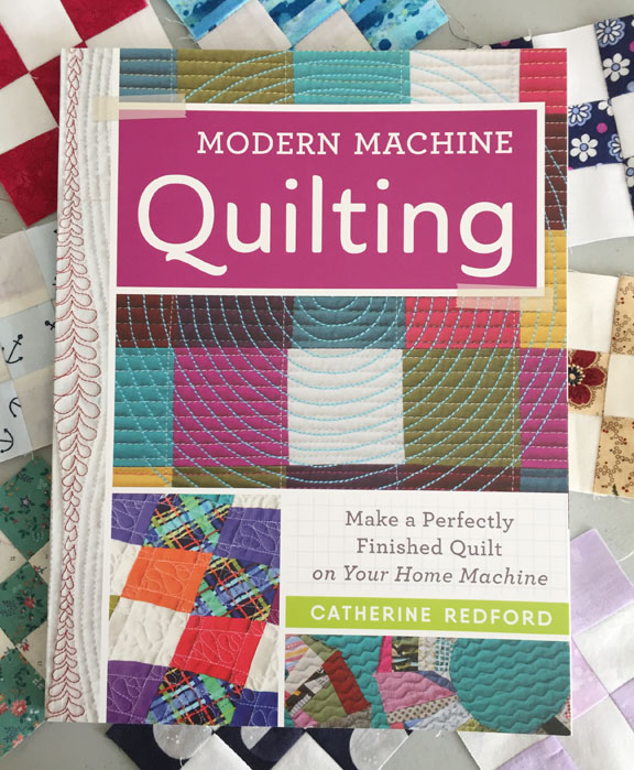 Image of the cover of Catherine Redford's book, titled Modern Machine Quilting: Make a Perfectly Finished Quilt on Your Home Machine. The book rests on a background of small nine-patch quilt blocks.